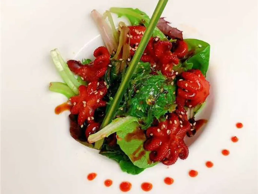 Octopus Salad is a dish of small octopus pieces mixed with fresh greens, seaweed at Blue Wazabi, a Japanese restaurant in NJ