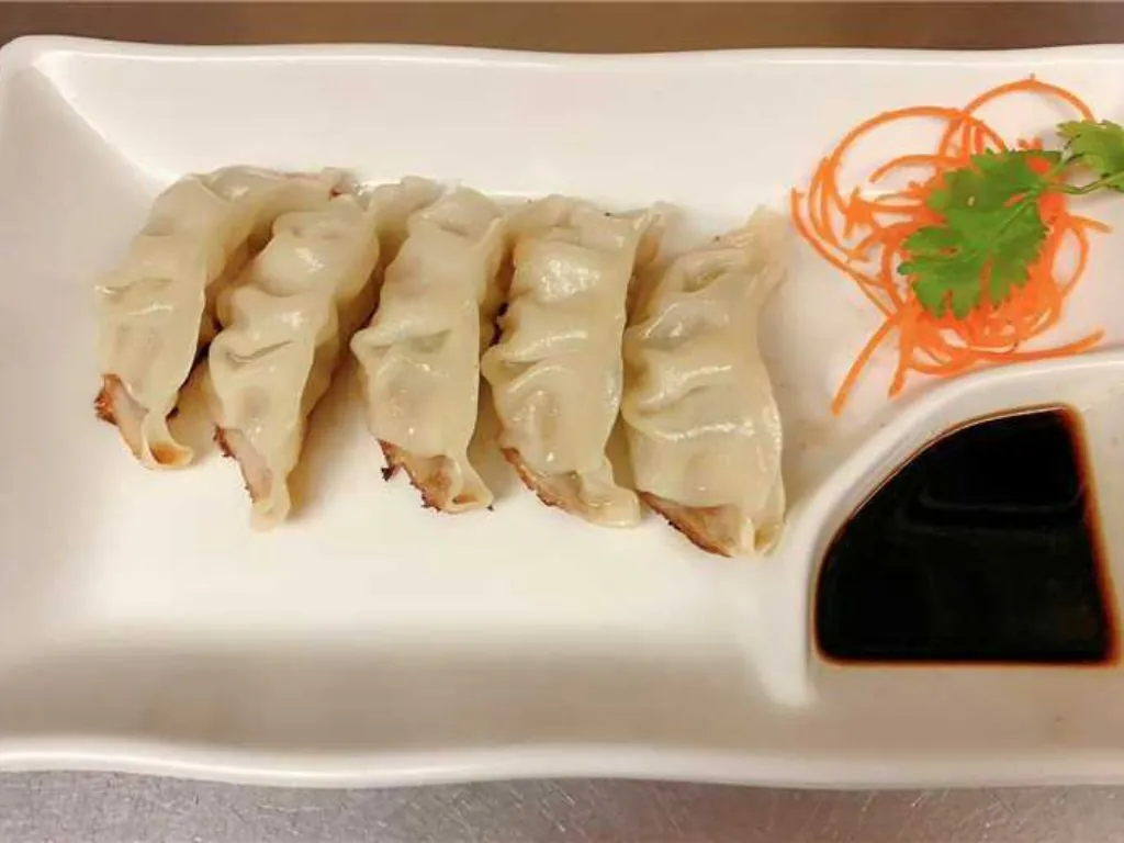 Pan - Fried Dumplings are golden - brown, crispy - skinned dumplings filled with savory ingredients at Blue Wazabi, a Japanese restaurant in NJ