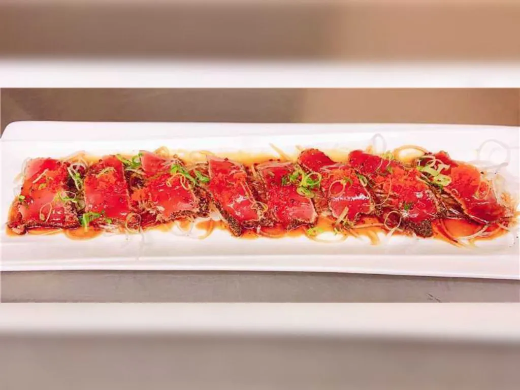 Seared Tuna features slices of fresh tuna lightly seared, garnished with shredded onions and green herbs at Blue Wazabi, a Japanese restaurant in NJ